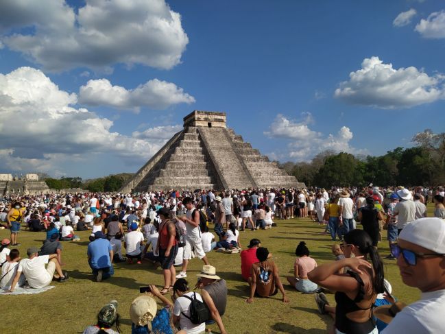 Turistas disfrutan del descenso de Kukulcán en Chichén Itzá